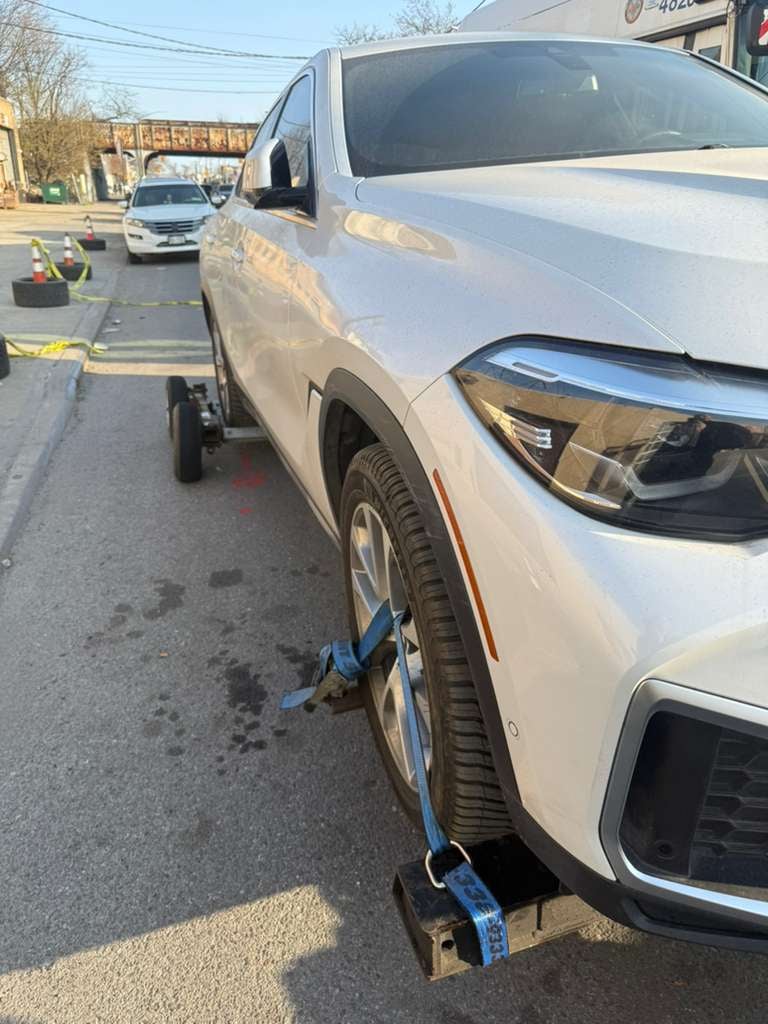 BMW X6 wheel-lift pickup in Queens, NY White BMW X6 on JG Towing wheel-lift by the elevated subway tracks in Queens, NY.