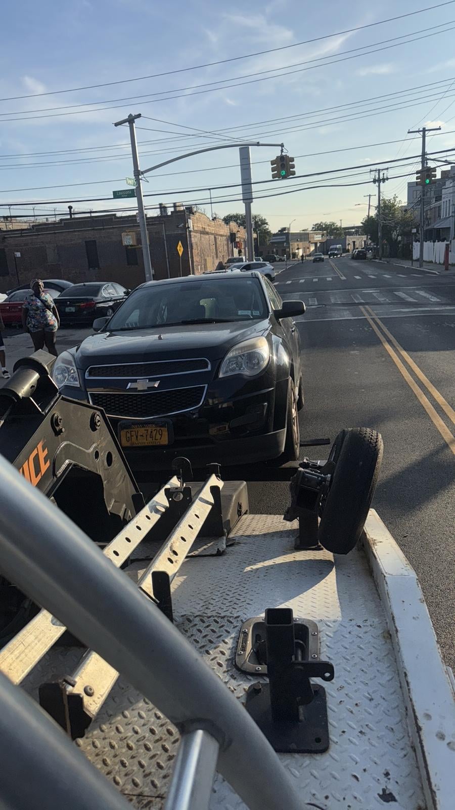 Chevy Equinox pickup on a Queens avenue Chevy Equinox on JG Towing wheel-lift truck on a Queens commercial avenue.
