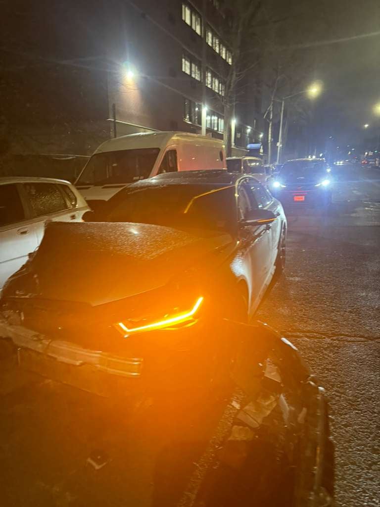 Dodge Charger after-hours recovery in Queens, NY Damaged Dodge Charger with DRL lit during a night recovery by JG Towing in Queens.