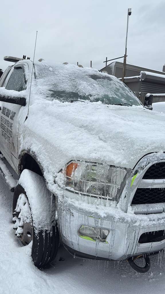 Winter storm response — ice-caked wrecker JG Towing Ram wrecker covered in snow and ice after a Queens winter storm.