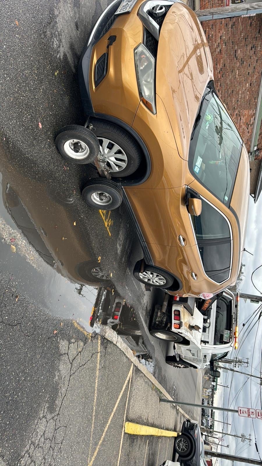 Luxury sedan wheel-lift recovery Gold Lexus sedan loaded on JG Towing wheel-lift on a Queens side street.